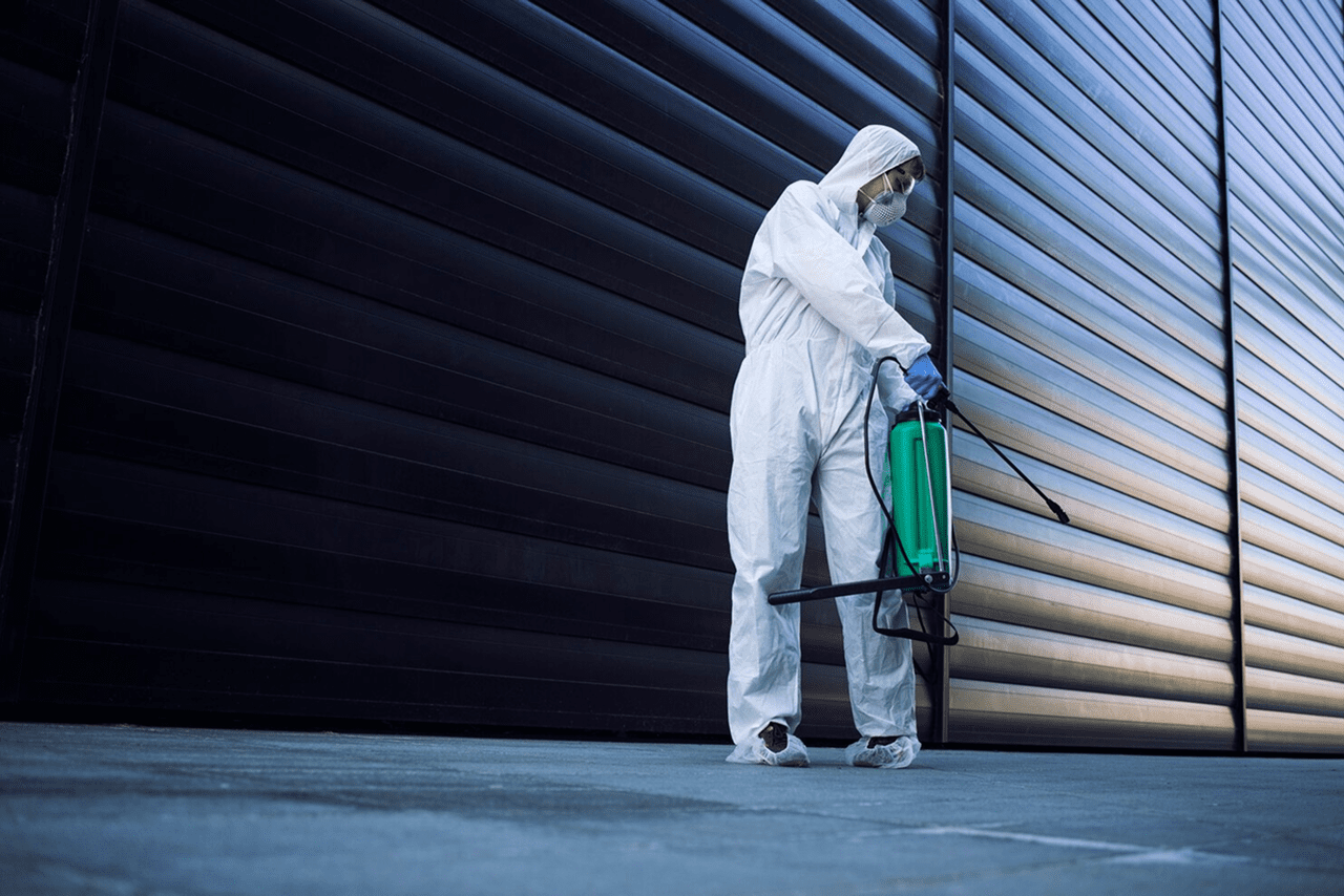 Pest control technician applying treatment inside a residential property
